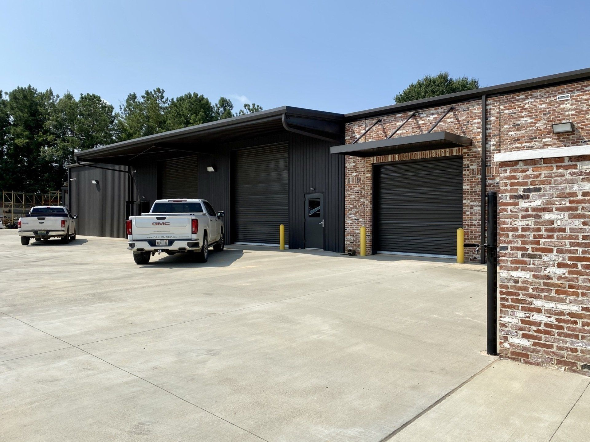 Two trucks are parked in front of a brick building