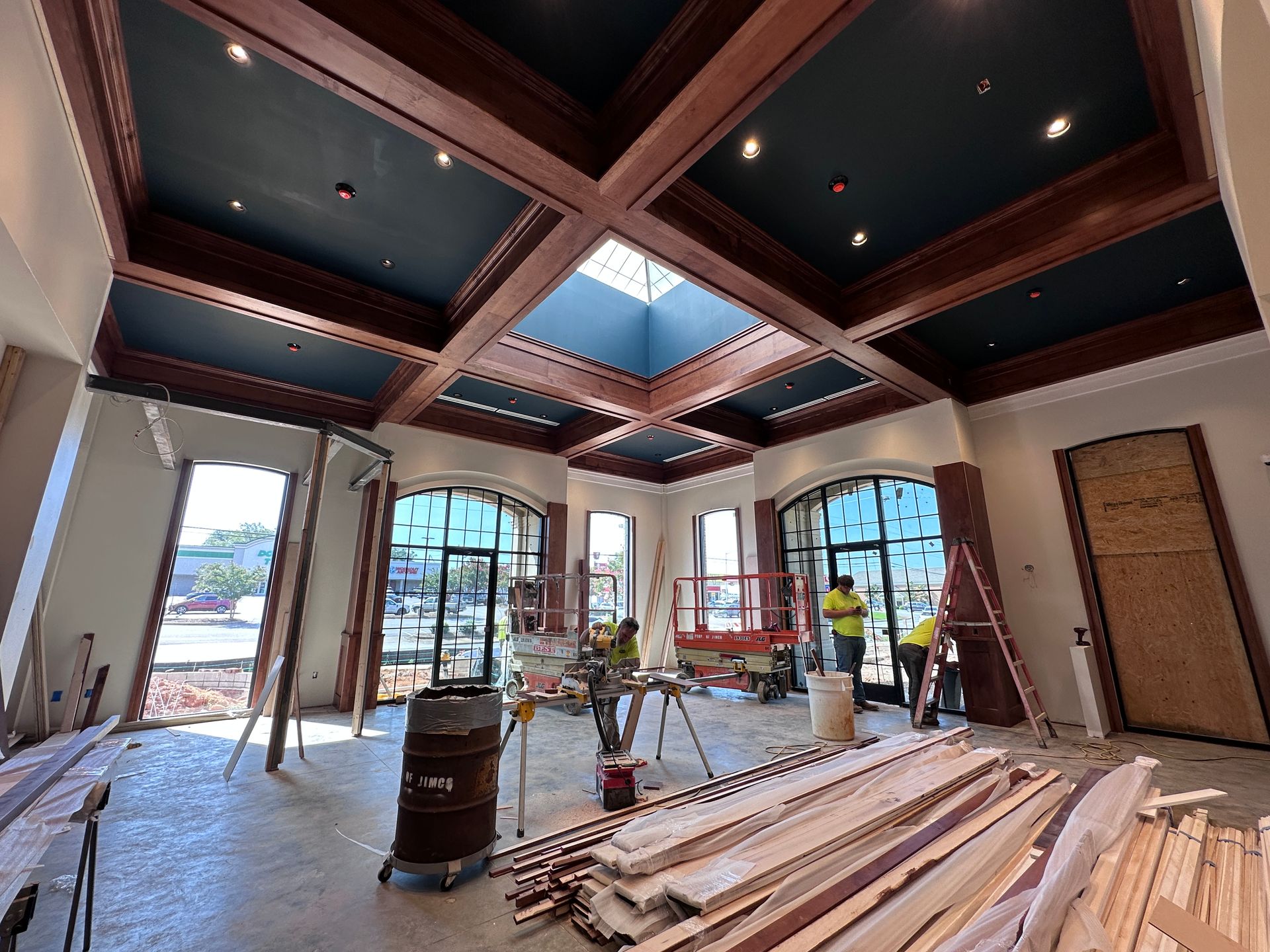 Partially finished room with exposed beams, skylight, windows, and stacks of construction materials