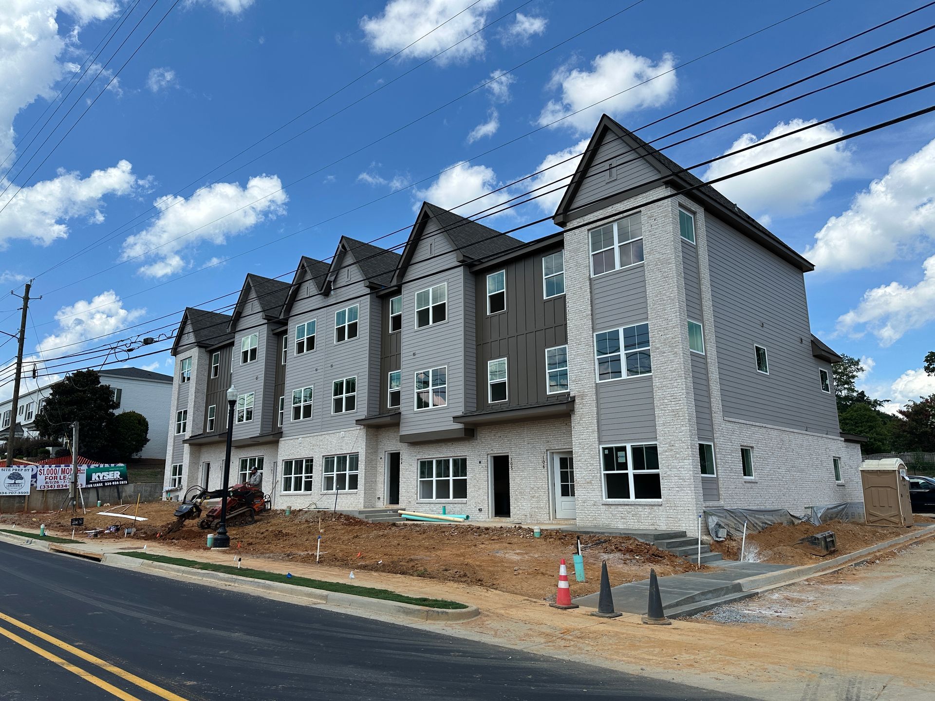 An aerial view of a new Hovey Precast office building with a blue roof surrounded by trees.