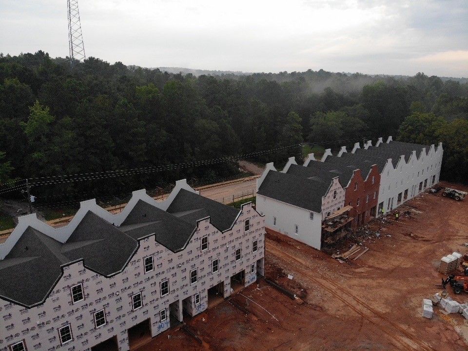 An aerial view of a building under construction in the middle of a forest.