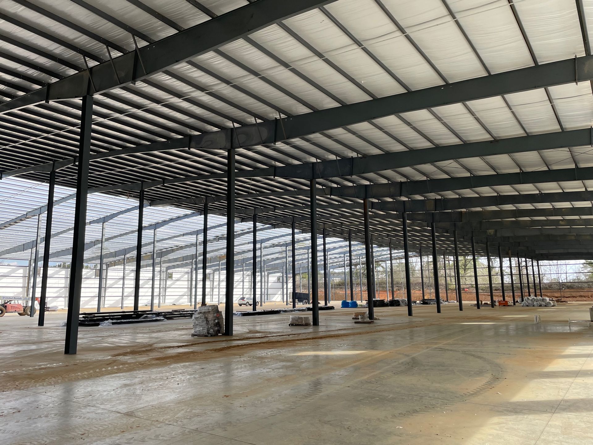 The inside of a large building under construction with a lot of metal beams.
