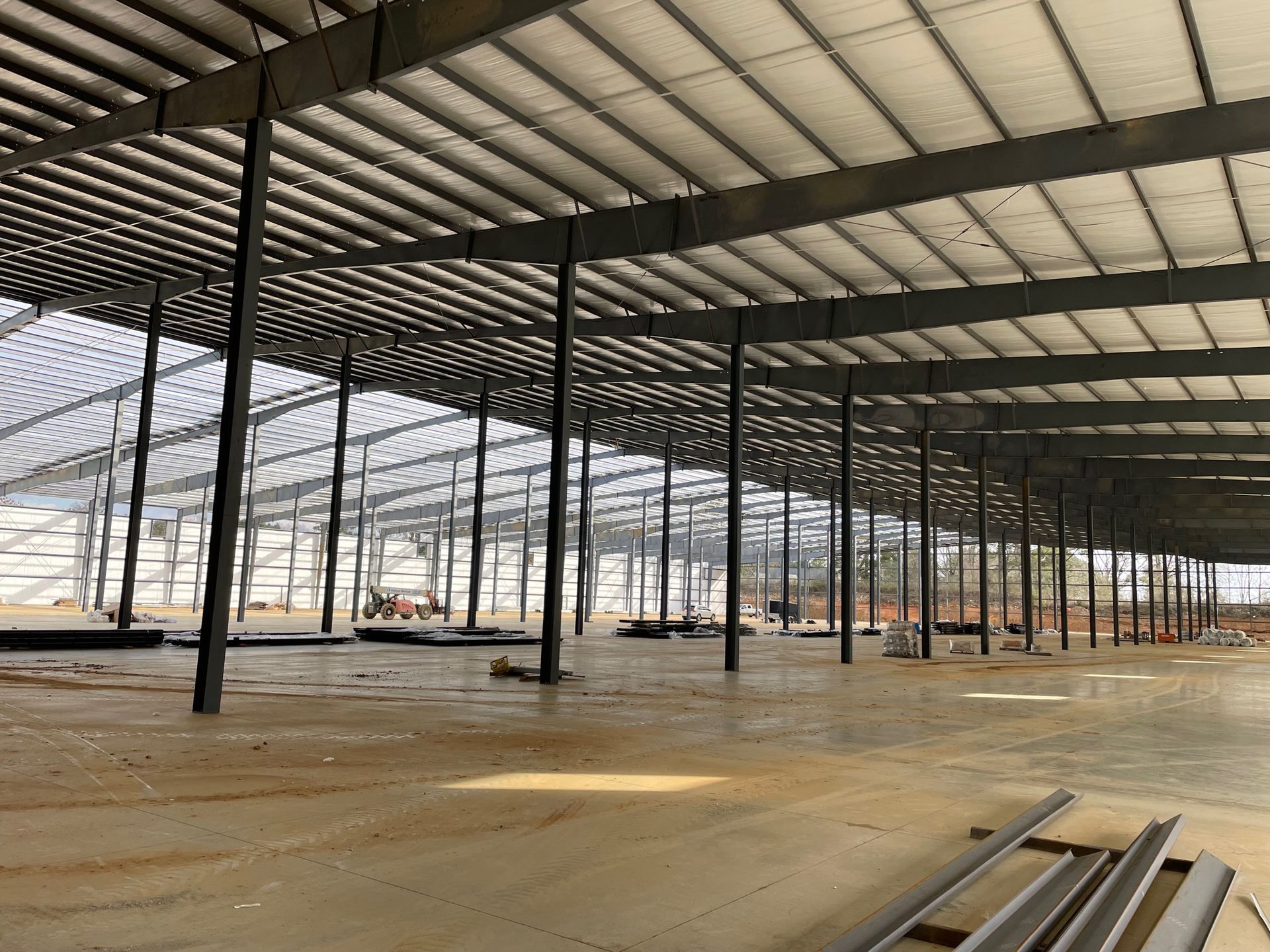 A large warehouse under construction with a lot of steel beams.
