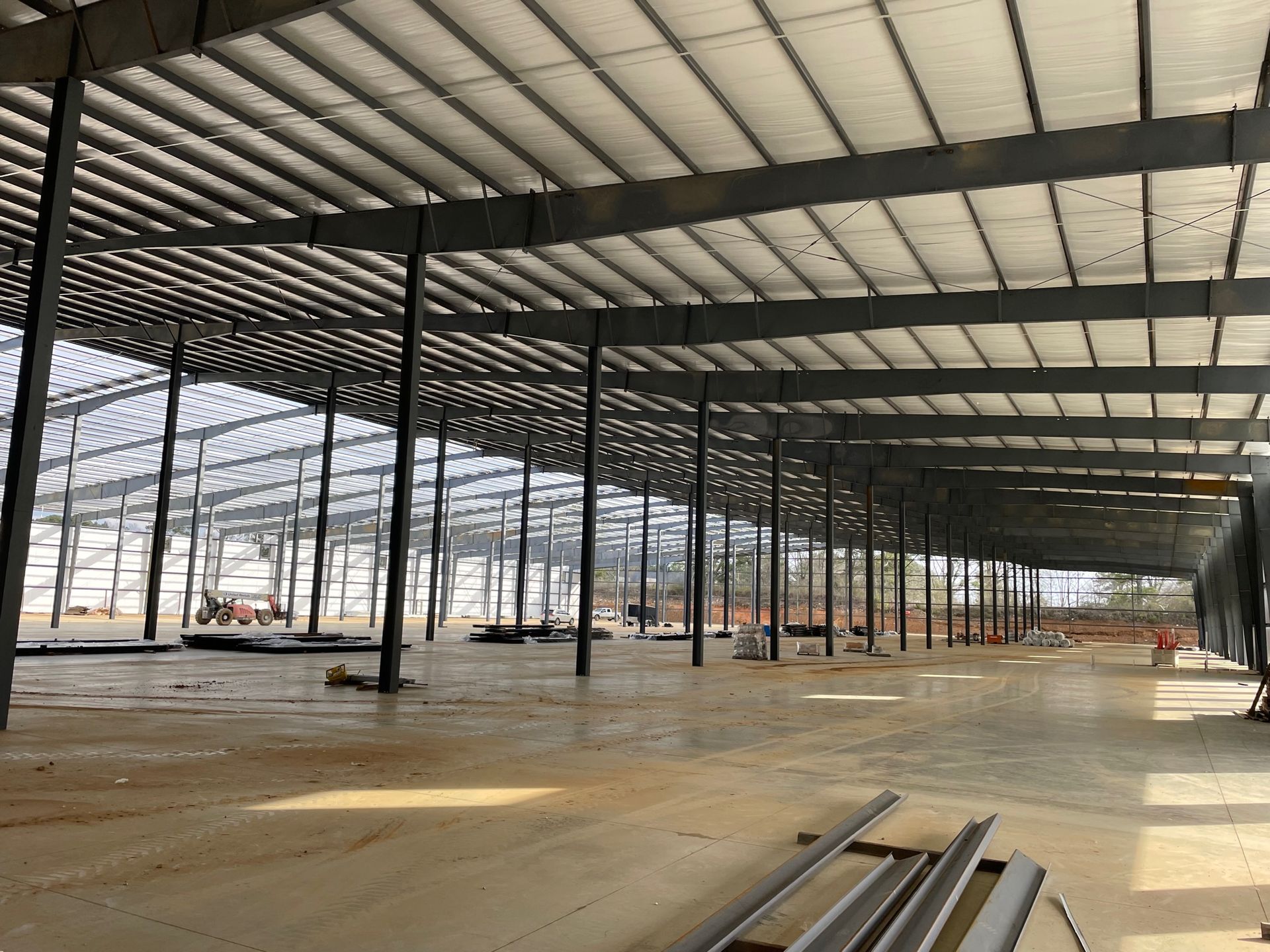 A large warehouse under construction with a lot of metal beams.