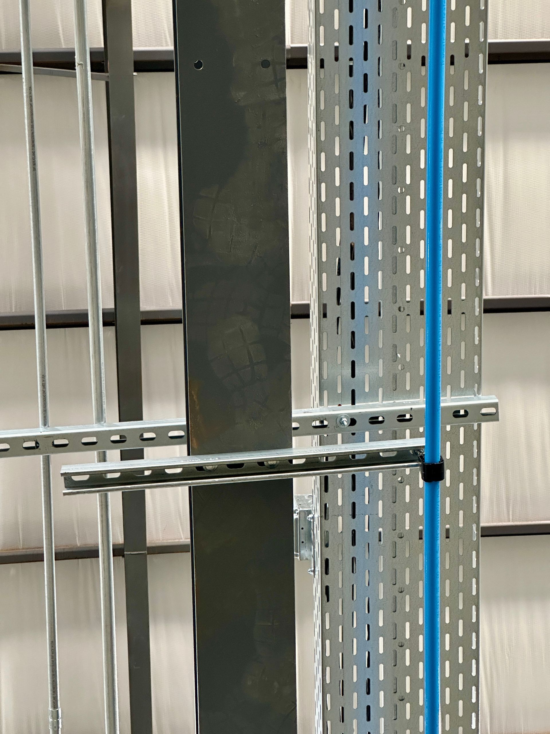 A blue pipe is attached to a metal pole