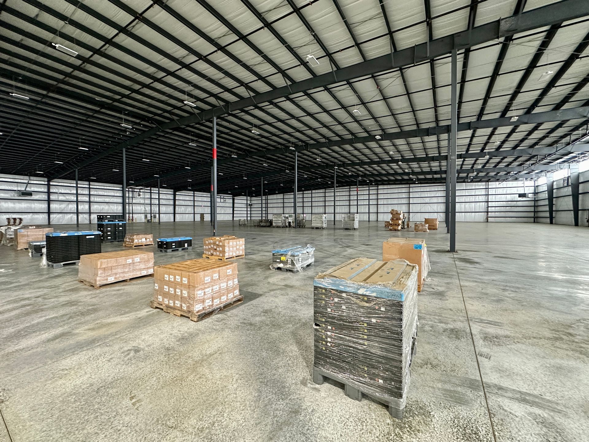 A large warehouse filled with lots of boxes and pallets.