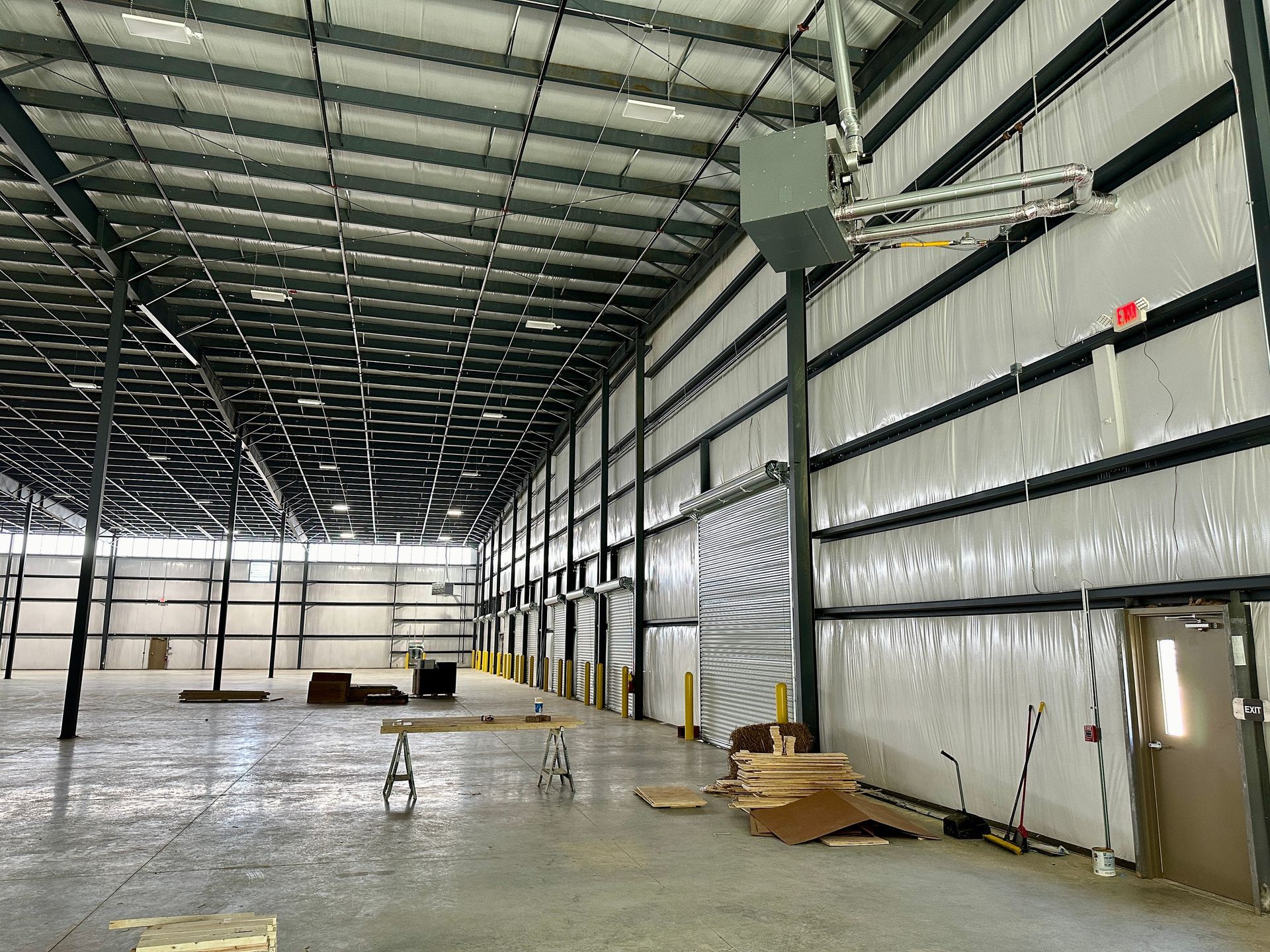 A large empty warehouse with a ceiling fan hanging from the ceiling.