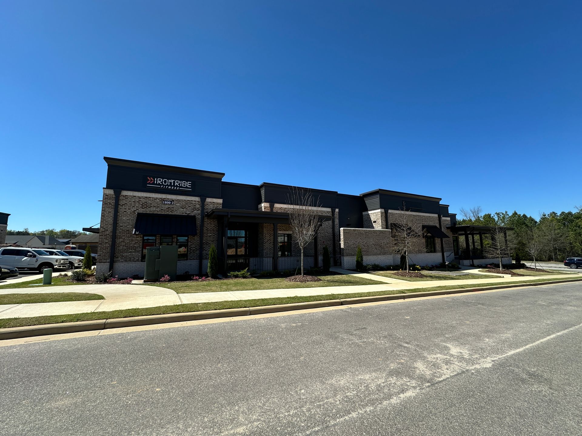 A large building with a lot of windows is sitting on the side of the road.