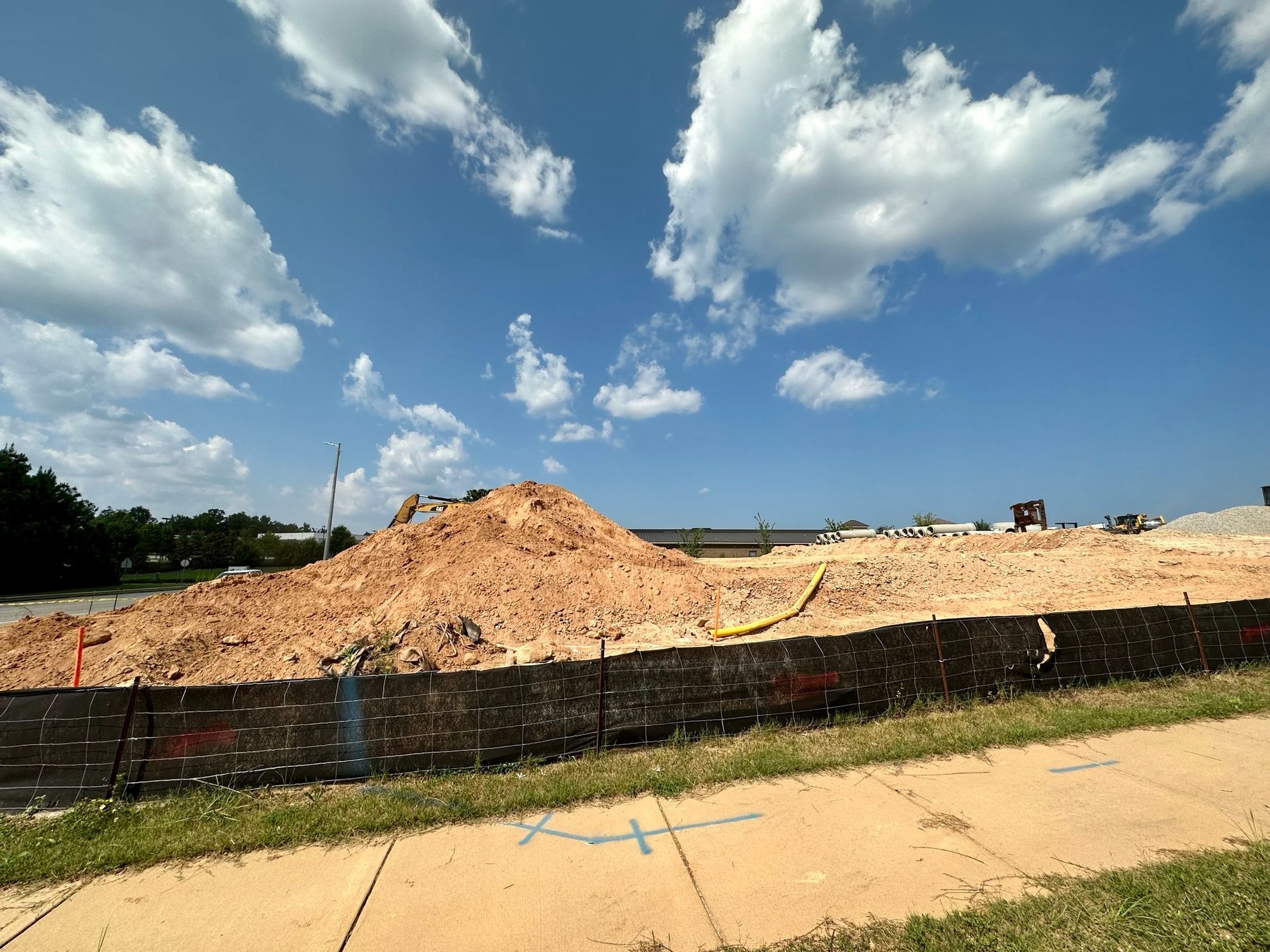A large pile of dirt is sitting on the side of the road.