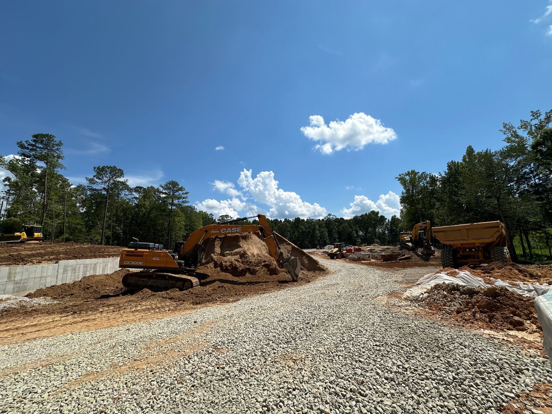Construction site with excavators and gravel piles under a blue sky