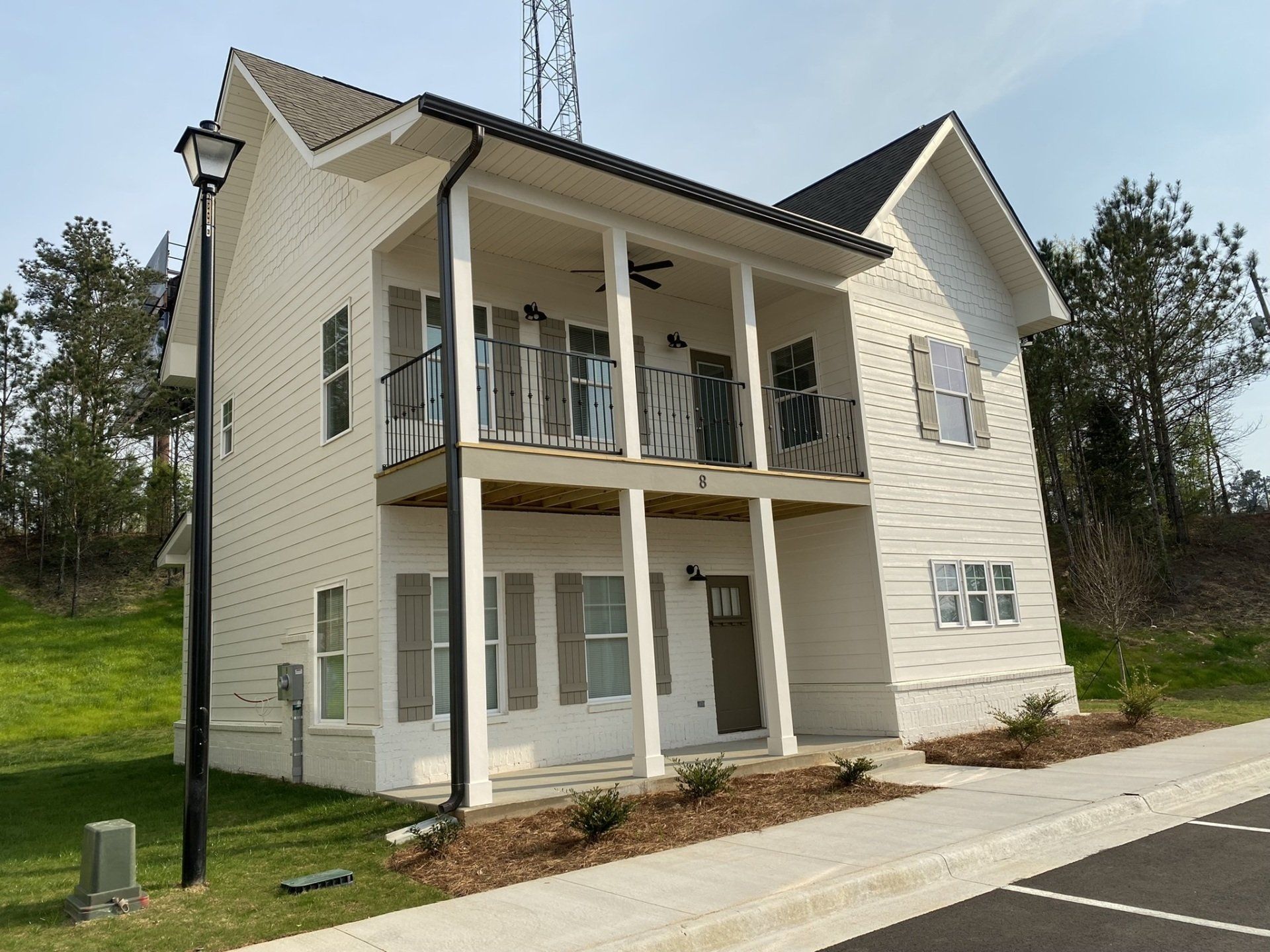 A white house with a balcony and a street light in front of it