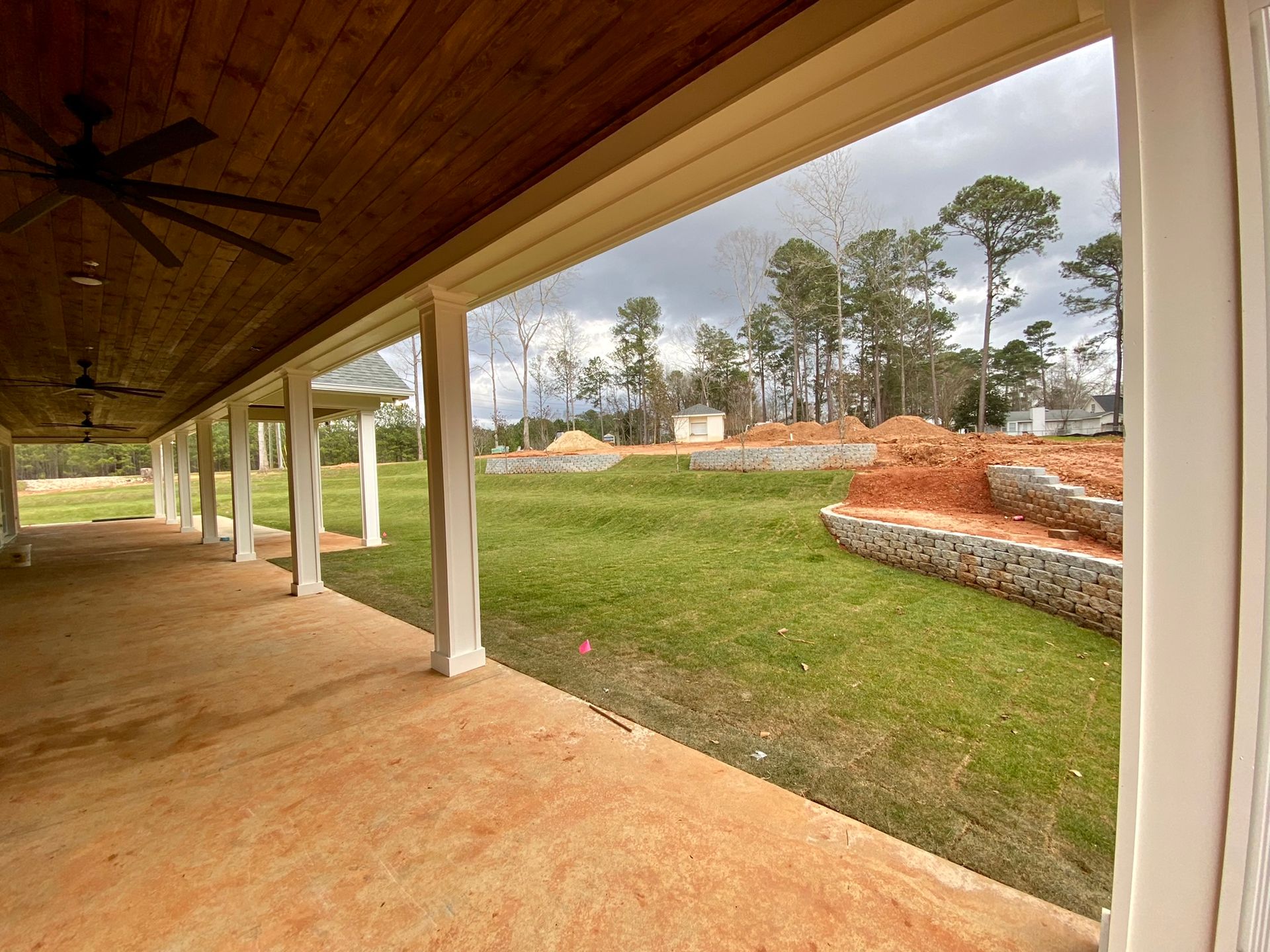 A porch with a ceiling fan and a view of a grassy field
