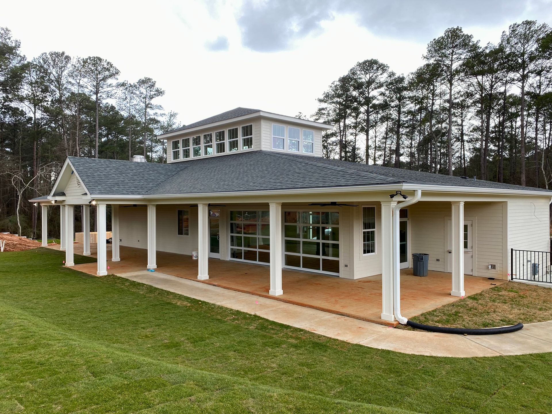 A large white house with a gray roof and a large porch