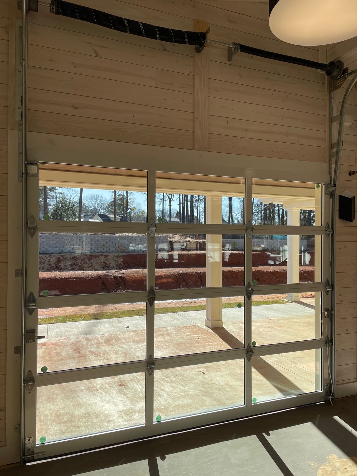 A garage door with a lot of windows and a view of the outside.