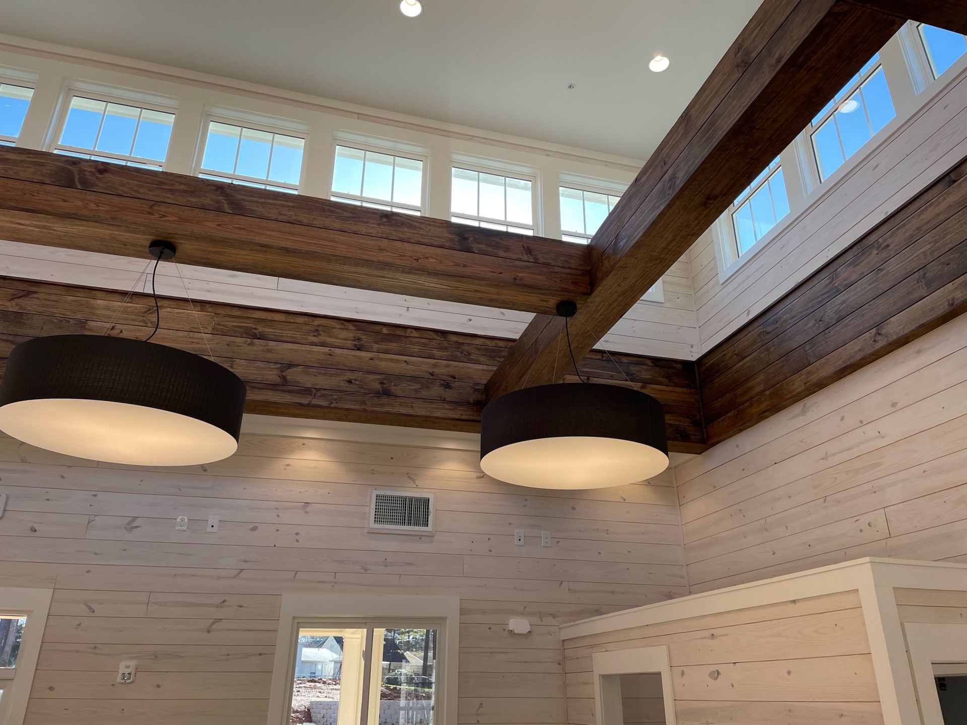 A room with a wooden ceiling and a lot of windows