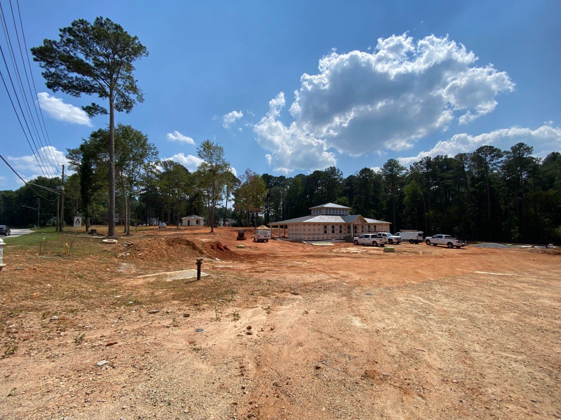 A large dirt field with a house in the background