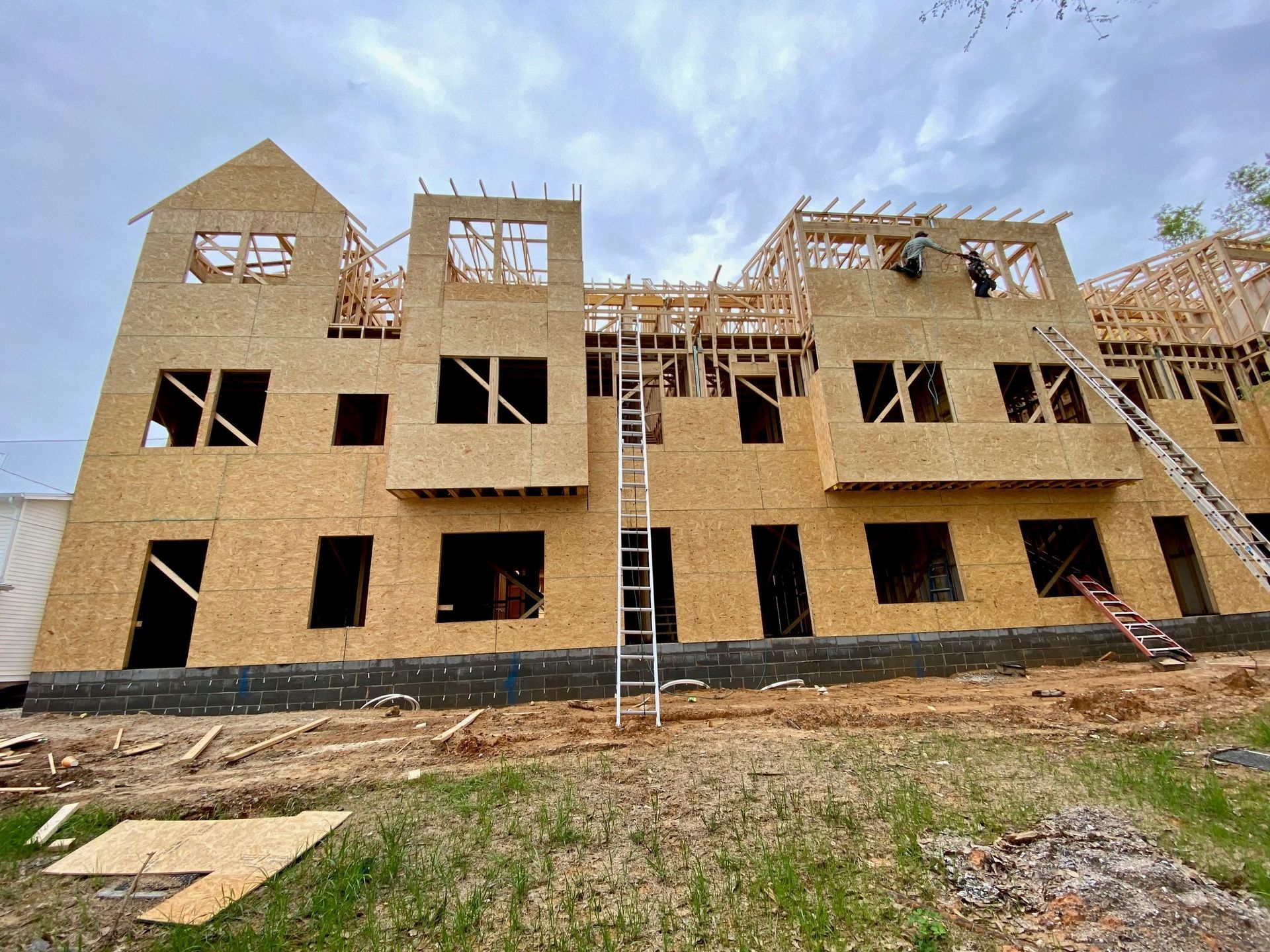 A large wooden building under construction with a ladder in front of it.