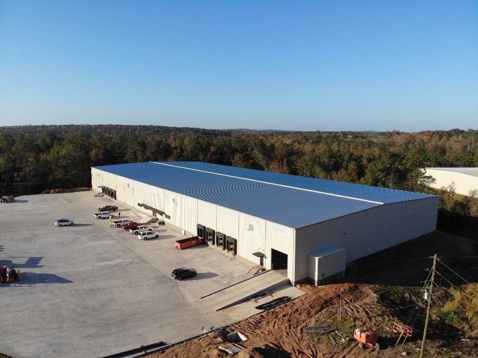 An aerial view of a large building with a parking lot in front of it.