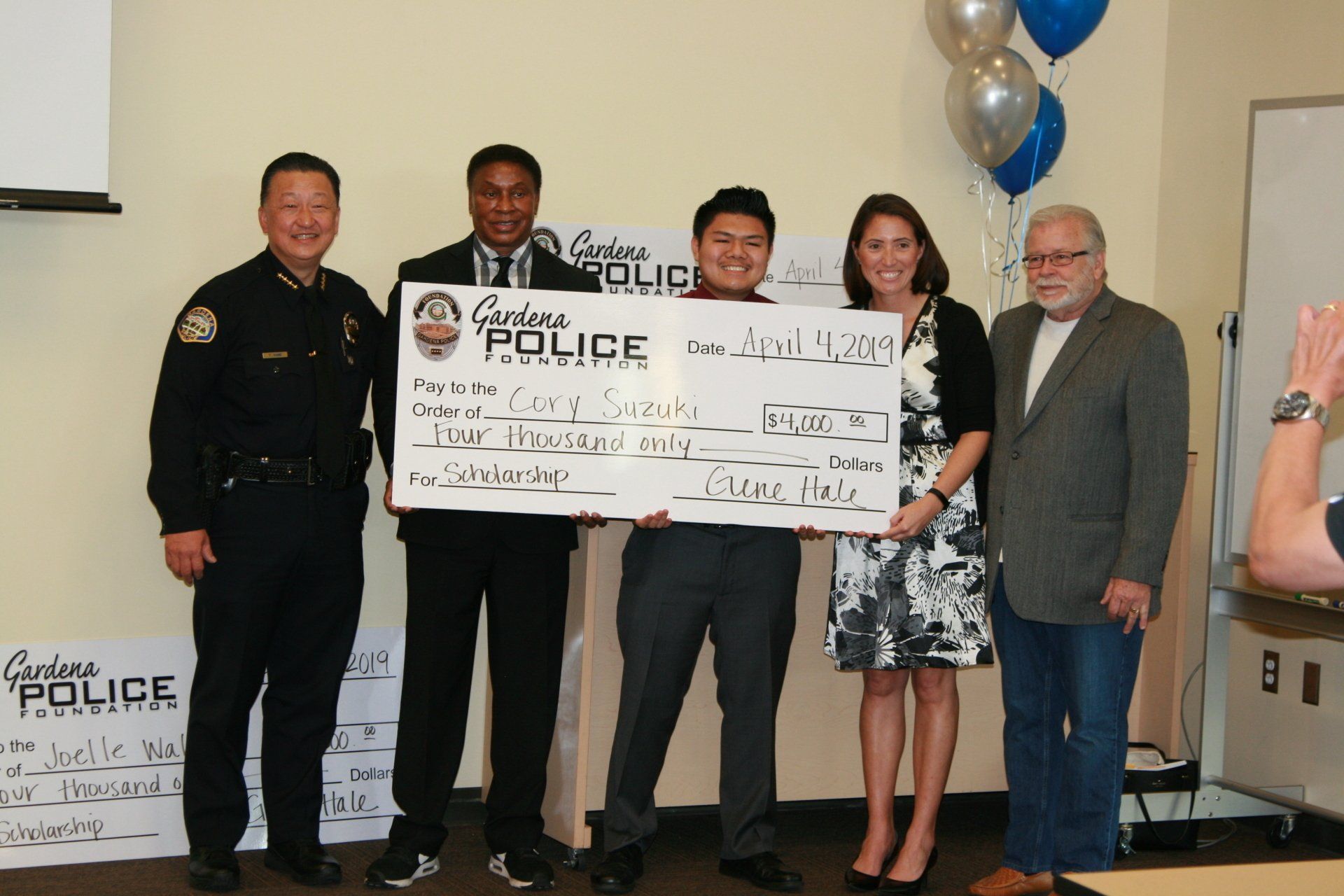 A group of people holding a large check that says police on it