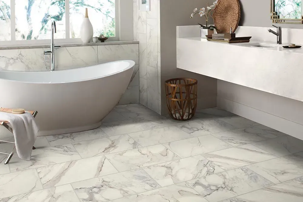 Luxurious white marble bathroom with a freestanding tub, double vanity, and basket.