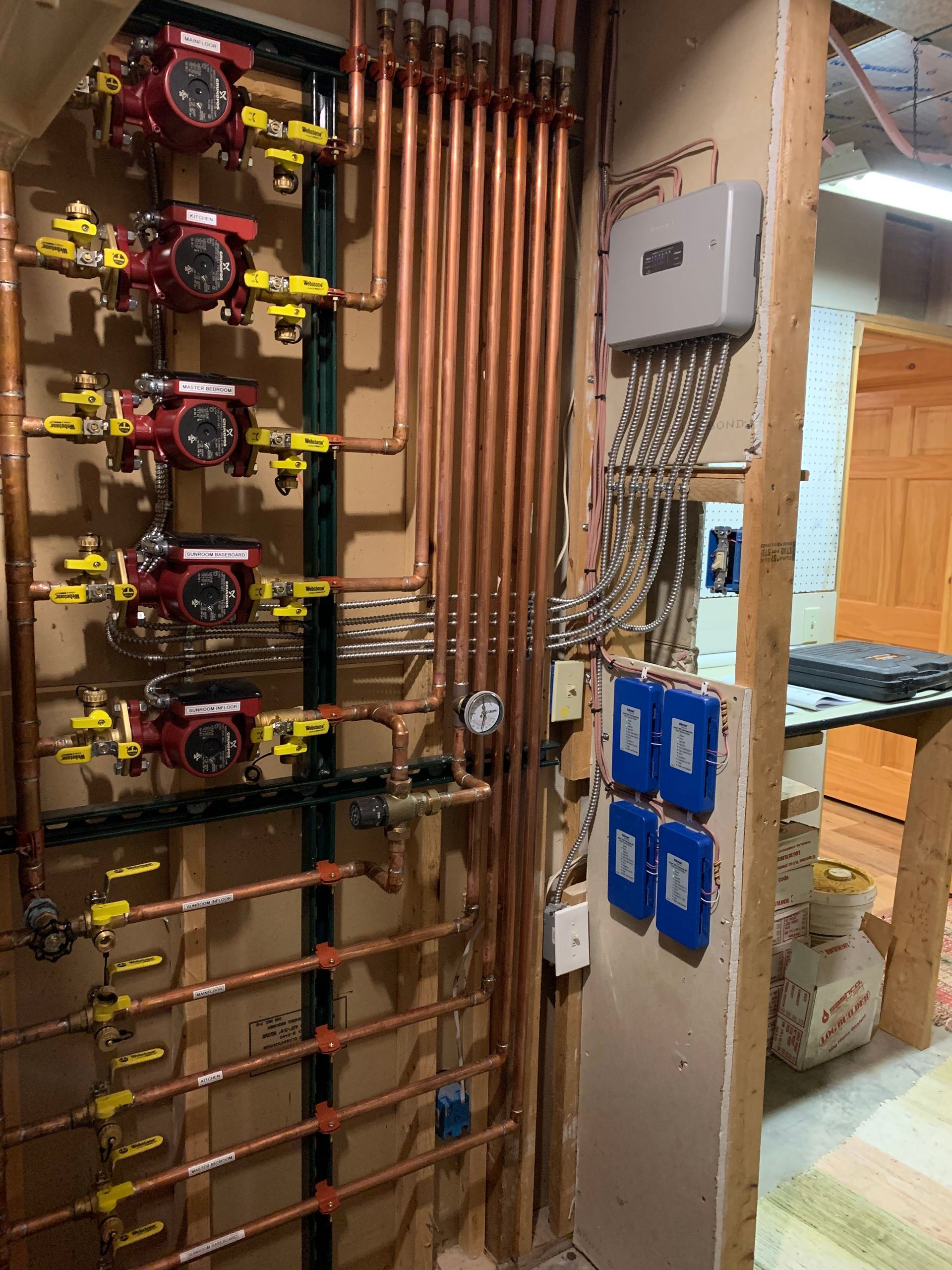A wall with a lot of copper pipes and meters on it