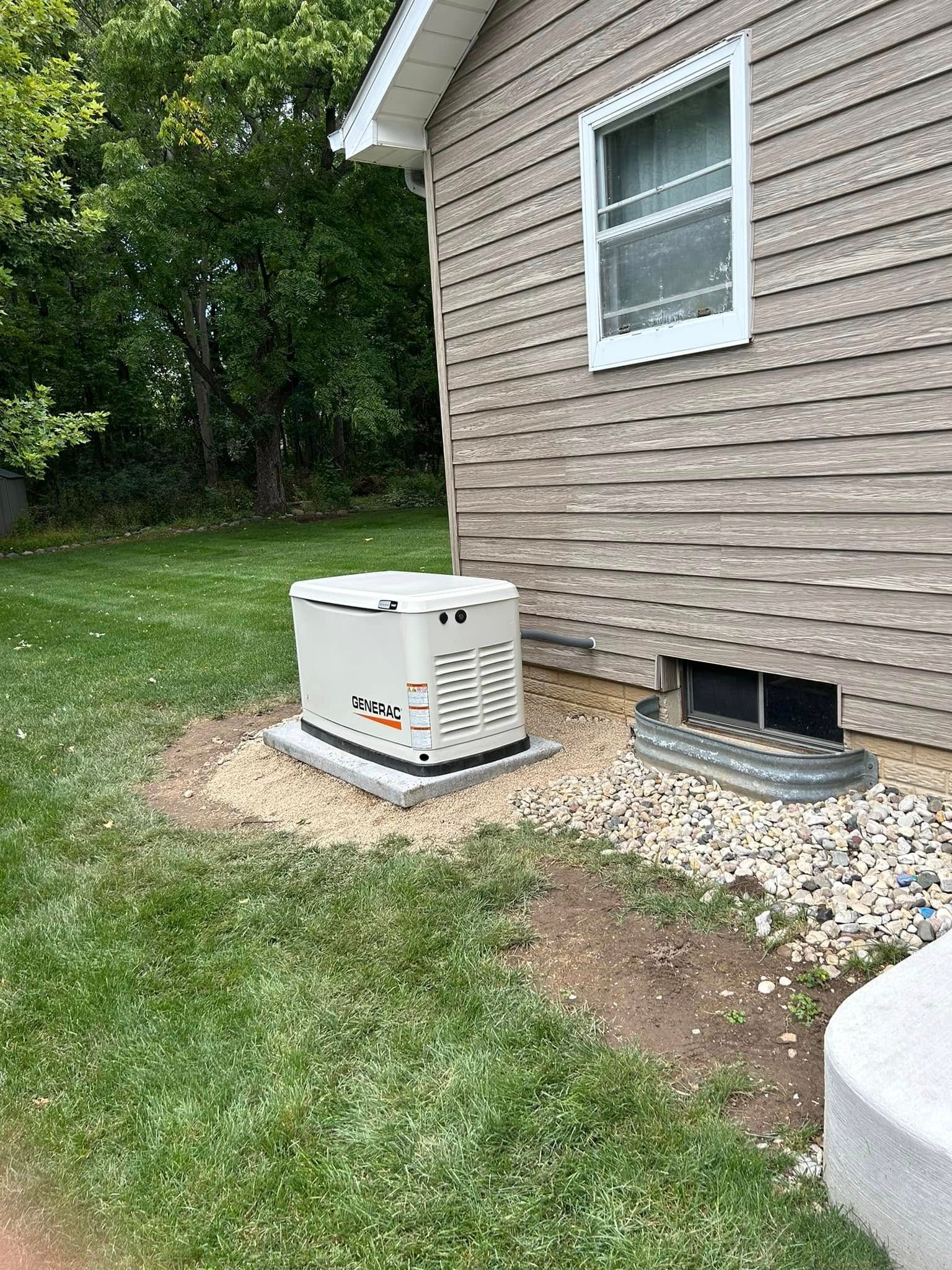 Outdoor home generator beside beige house, with gravel base and grassy yard.