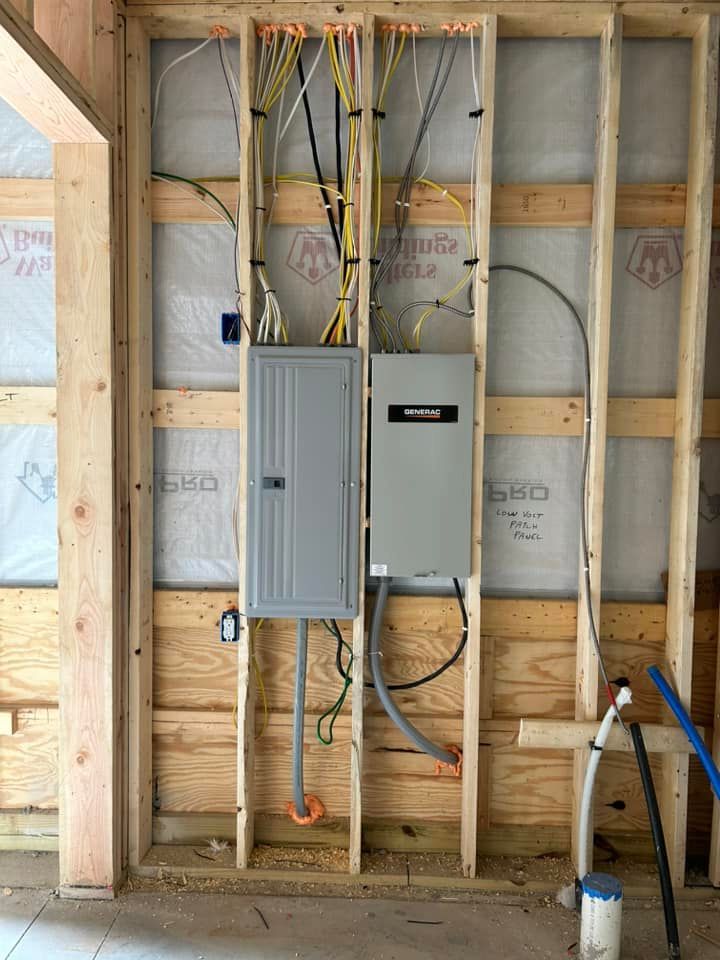 Exposed electrical panels and wiring installed in unfinished wall framing inside a construction site.