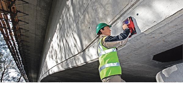 A construction worker is working on a concrete wall.