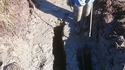 A person is digging a hole in the ground with a shovel.