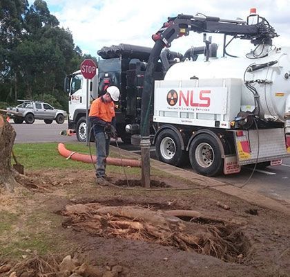 A man is standing in front of a nls truck
