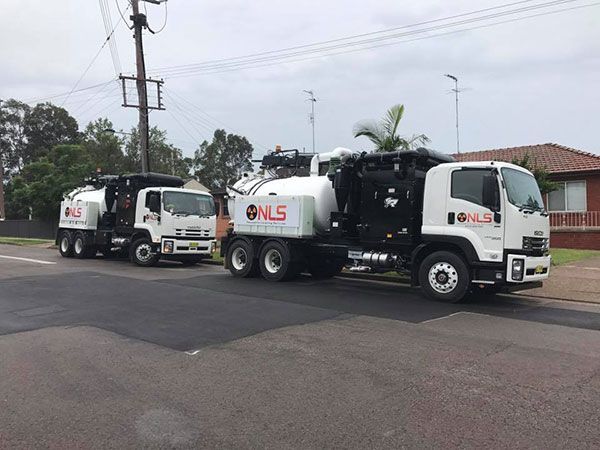 Two trucks are parked on the side of the road.