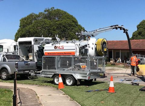 A vacuum truck is parked in front of a house.