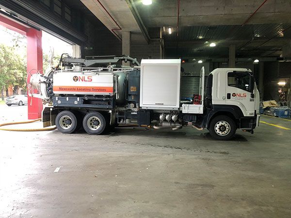 A vacuum truck is parked in a parking lot.