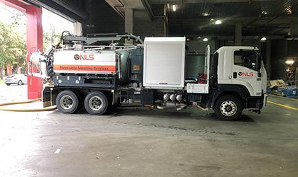 A vacuum truck is parked in a parking lot.