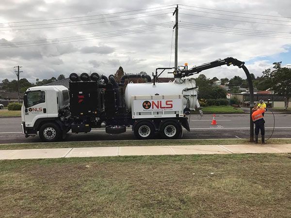 A vacuum truck is parked on the side of the road.
