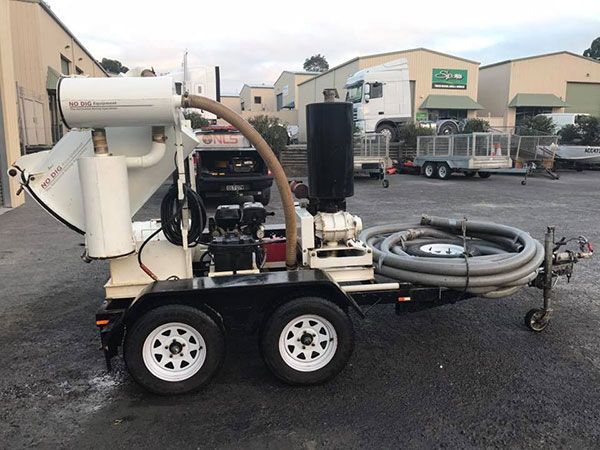 A trailer with a vacuum on it is parked in a parking lot