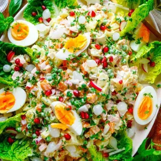 Een kleurrijke salade met eieren, sla, radijsjes, kaas en kruiden op een schaal.