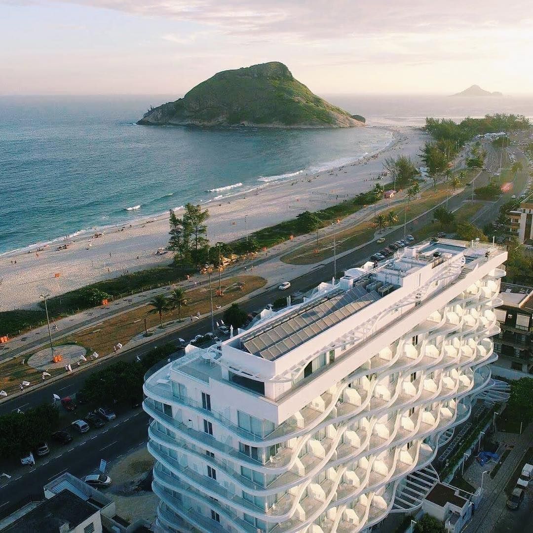 Uma vista aérea de um grande edifício branco próximo a uma praia.