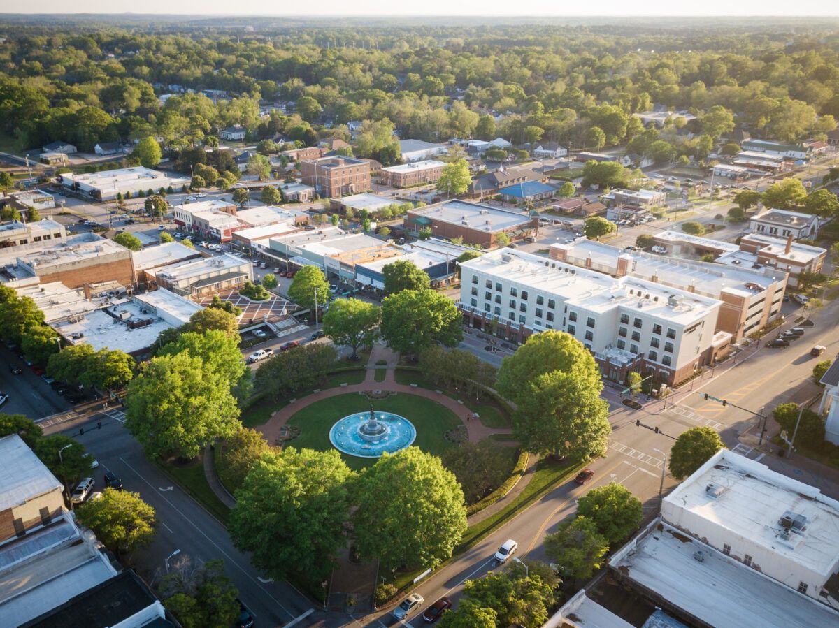 An aerial view of a city with a fountain in the middle of it.