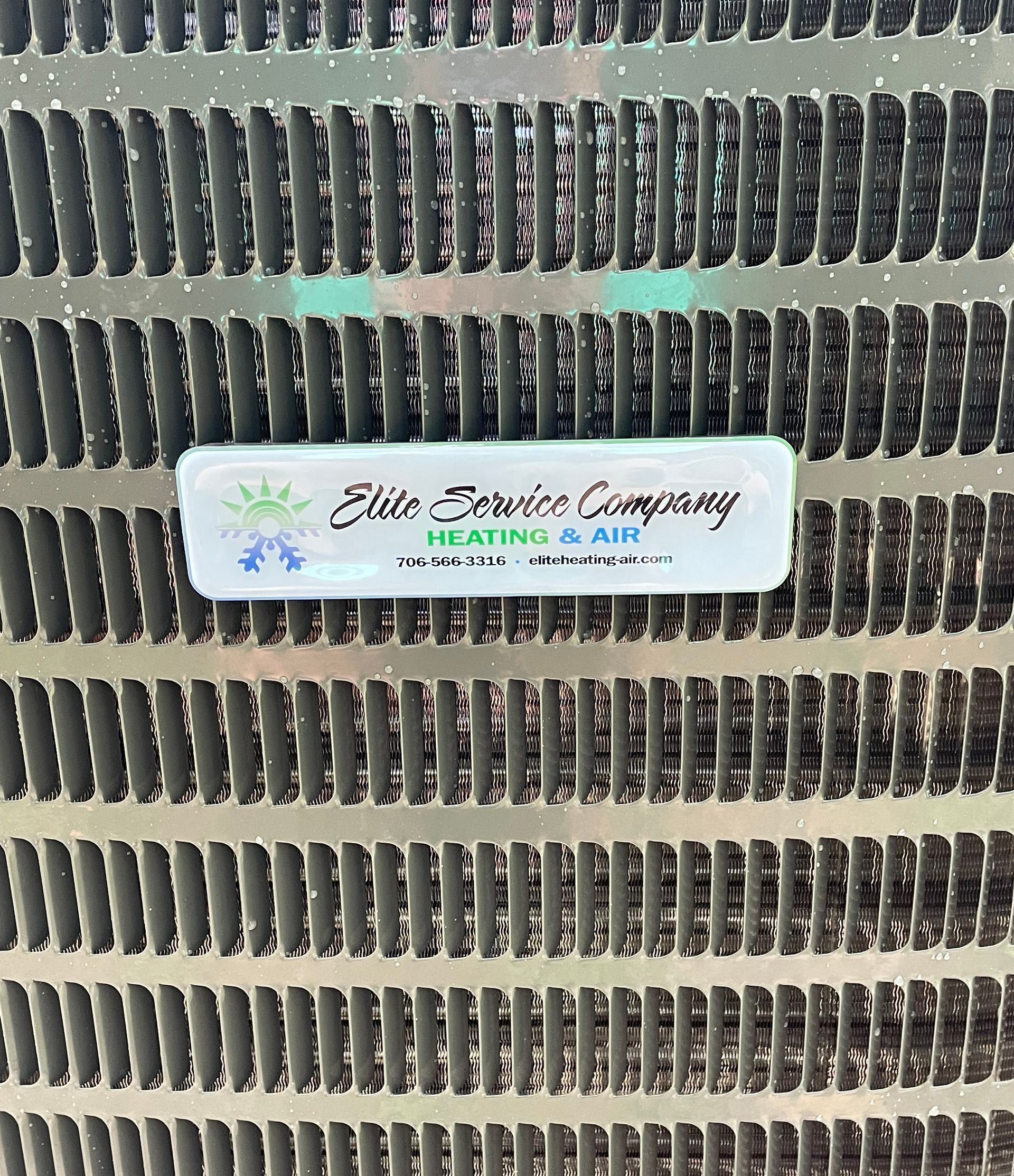 Close-up of an AC unit's metallic fins with a sticker that reads