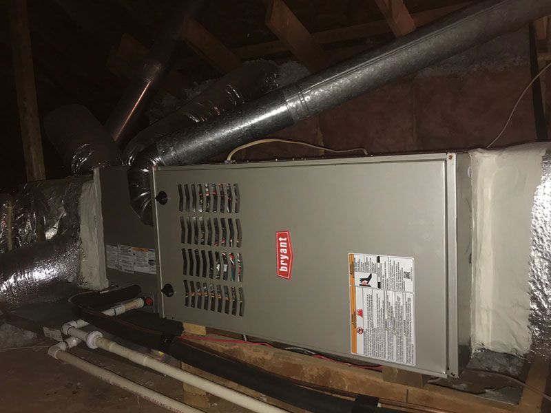 A furnace is sitting in the attic of a house.