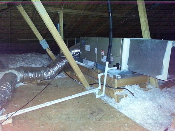 A picture of an attic with ducts and pipes