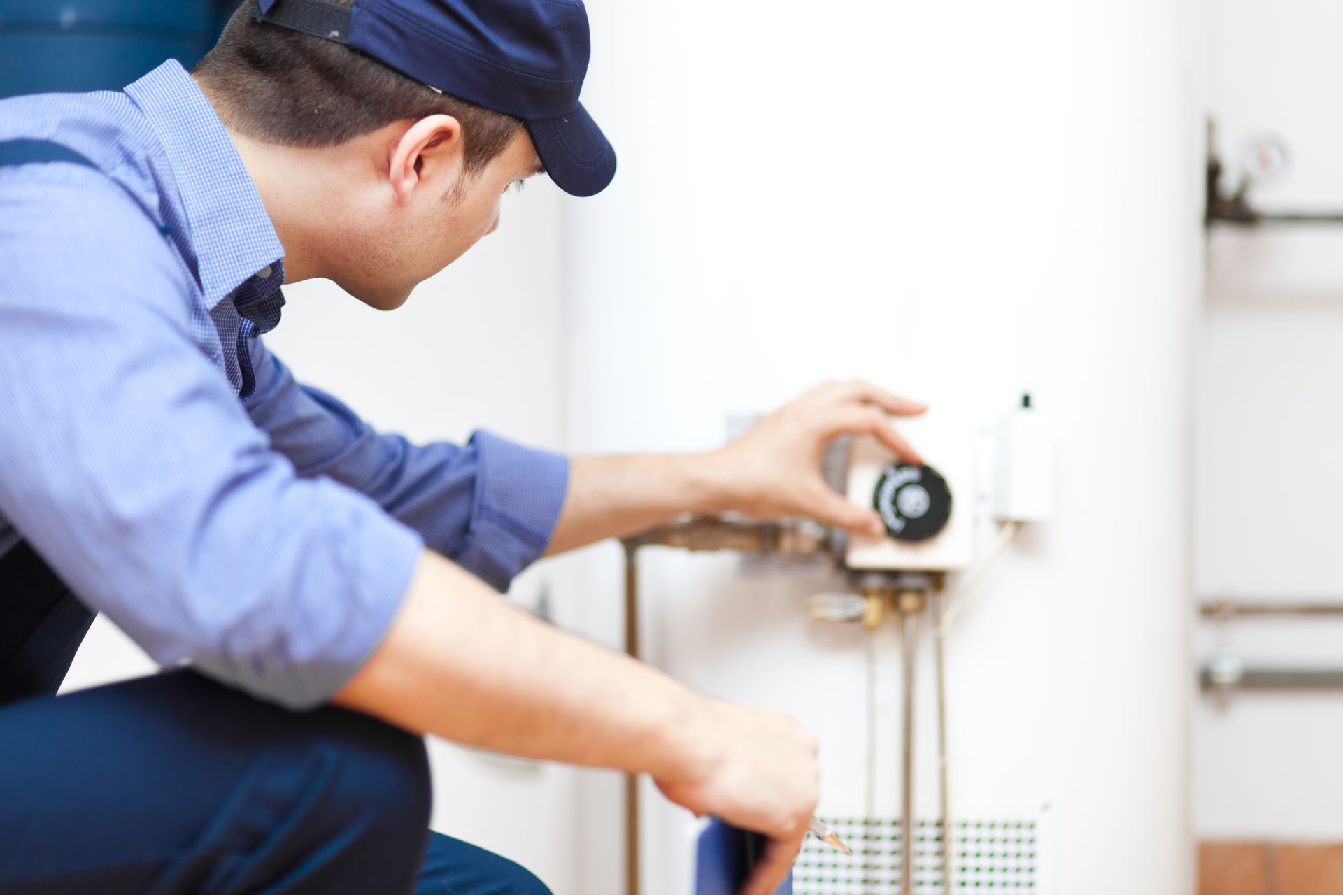 Technician adjusting water heater controls during Ellerslie GA startup testing