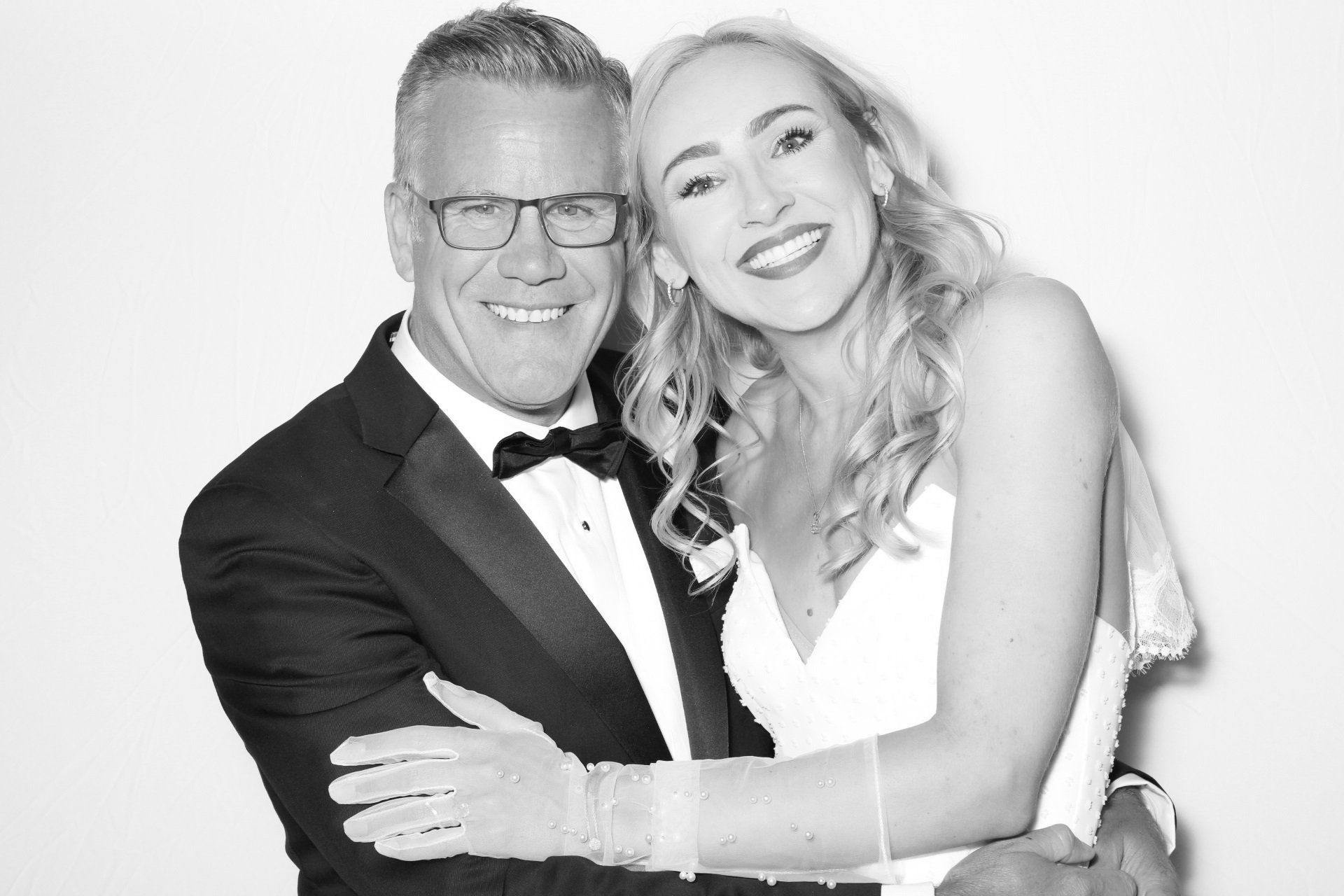 A black and white photo of a bride and her dad hugging each other.