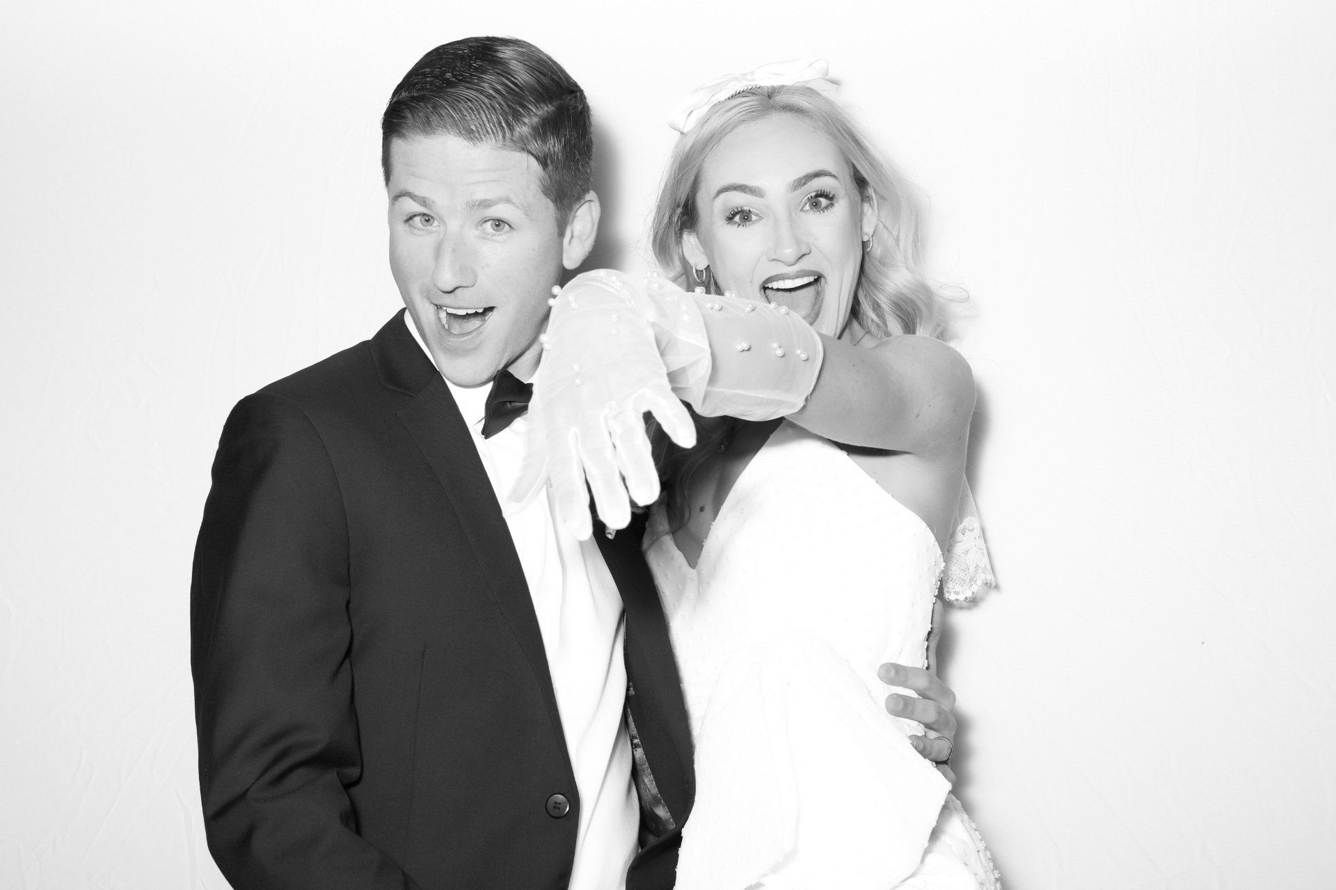 A bride and groom are posing for a picture in a photo booth.