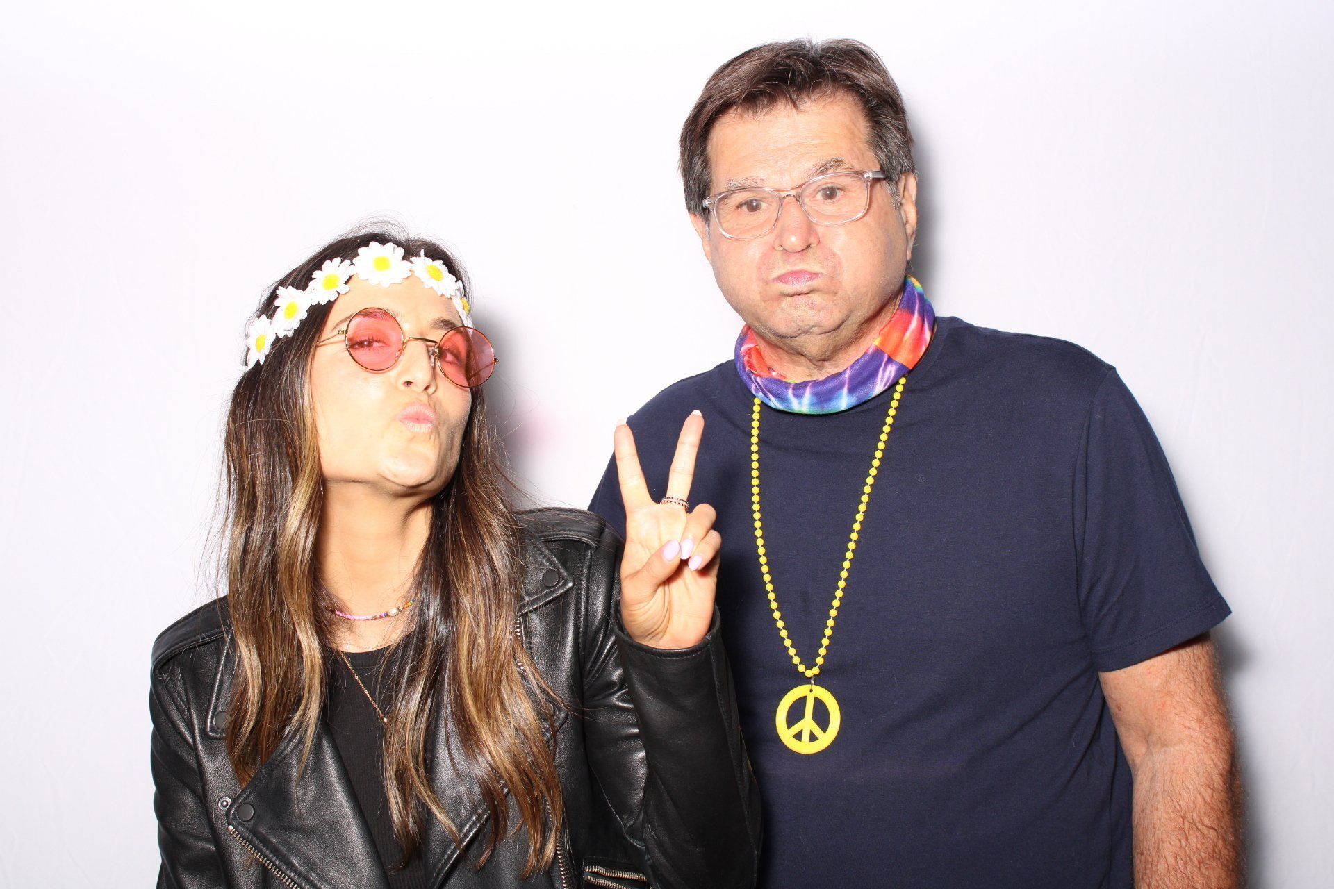 A man and a woman are posing for a picture in a photo booth.
