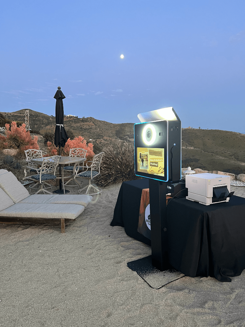 A photo booth is sitting on top of a table on the beach.