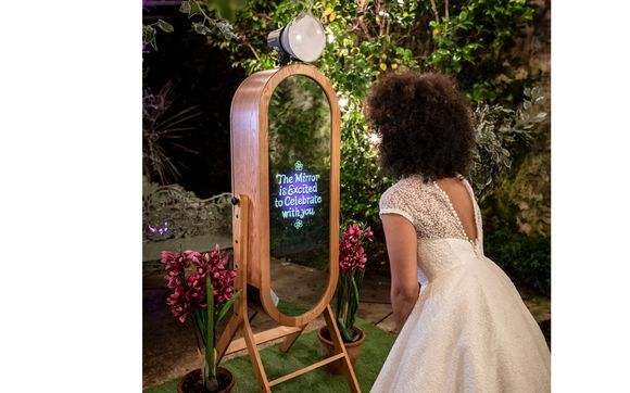 A woman in a wedding dress is standing in front of a mirror.