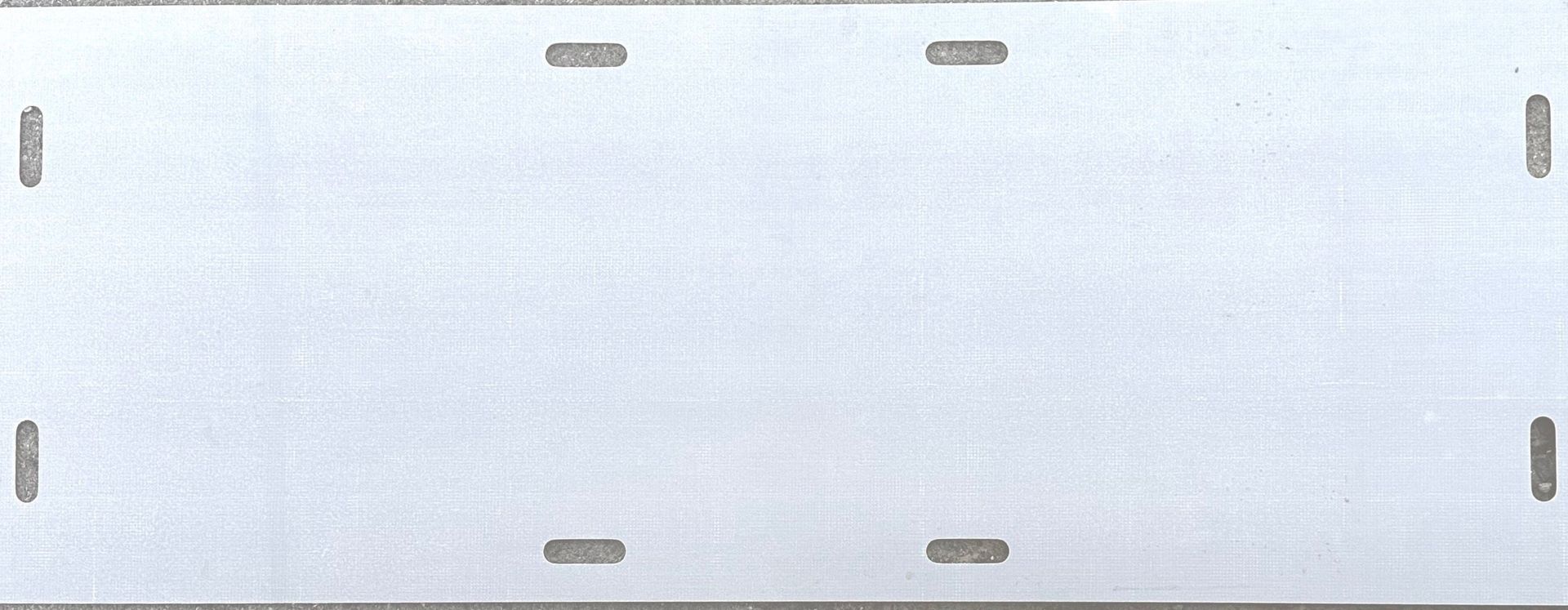 A rectangular light grey metal mounting plate with four vertical slots on the sides and four horizontal slots near the edges.