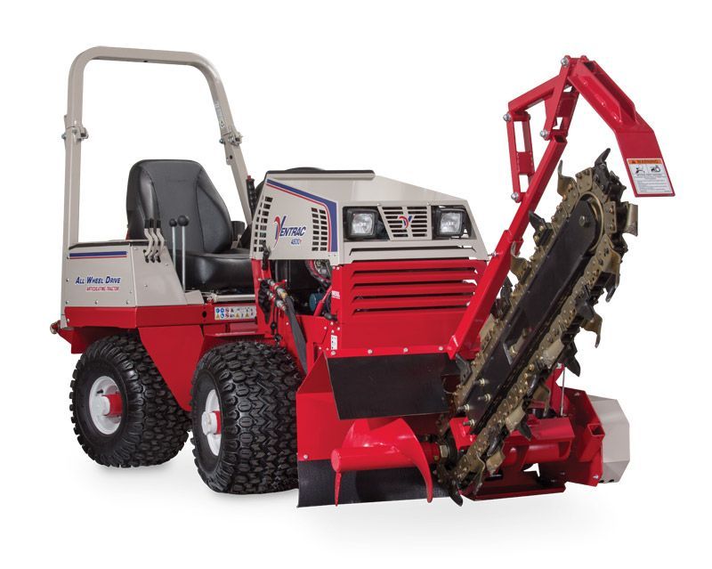 A red and white ride-on trenching machine with a large, heavy-duty digging chain assembly mounted on the front.