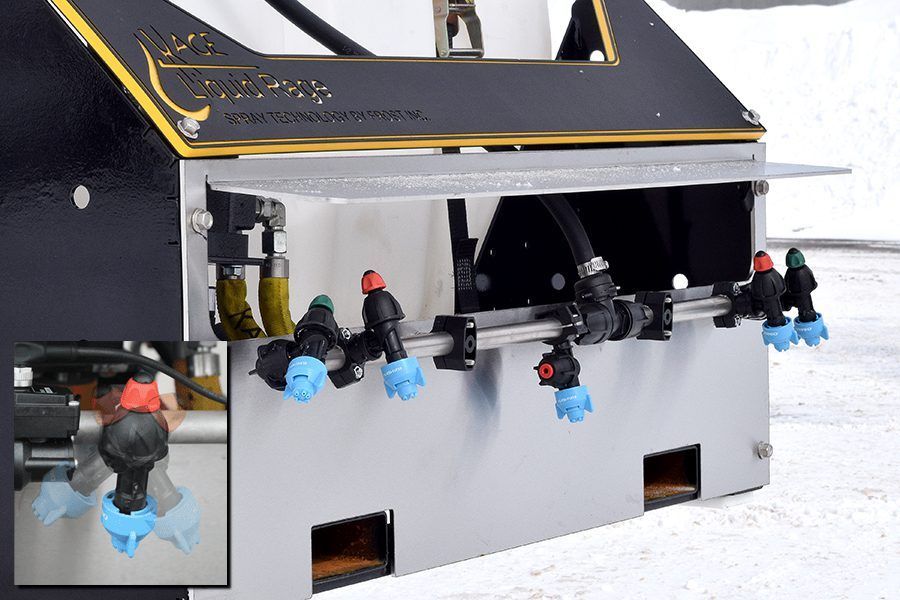 An agricultural machine part with a horizontal spray boom featuring multiple black nozzle holders with blue spray tips.